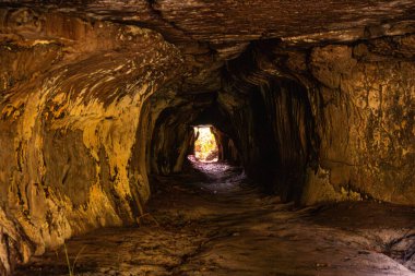 Kolombiya, Guaviare 'deki dingin bir mağara geçidi dokulu kaya oluşumlarıyla çevrili parlak bir açıklığa açılıyor.