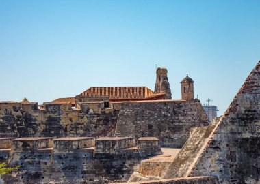 Kolombiya, Cartagena 'daki San Felipe Kalesi' nin pitoresk bir manzarası, açık mavi gökyüzünün altında tarihi mimarisini ve taş duvarlarını sergiliyor.