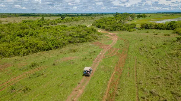 Kolombiya, Casanare 'deki yemyeşil manzaranın hava manzarası, dolambaçlı yollar ve bulutlu bir gökyüzünün altındaki açık alanlar.