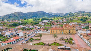 Mongui, Boyac, canlı mimari, yeşil tepeler ve büyüleyici bir kasaba meydanı manzarası..