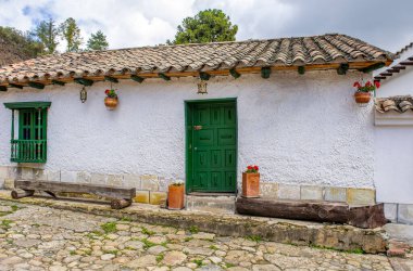 Mongui, Boyac, Kolombiya 'da çanak çömlek ve yeşillikle süslenmiş canlı bir duvar, yerel işçilik ve doğal güzellik sergiliyor..