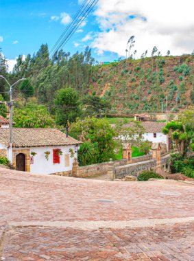 Mongui, Boyac 'ın pitoresk manzarası, güzel bir gökyüzü altında geleneksel mimari ve canlı yeşillik sergiliyor..