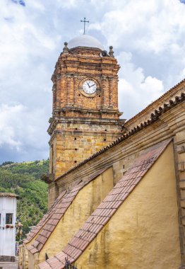 Mongui, Boyac 'ın pitoresk manzarası, güzel bir gökyüzü altında geleneksel mimari ve canlı yeşillik sergiliyor..