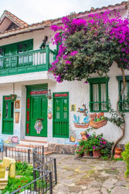Pueblito Boyacense, Duitama, Boyac, Kolombiya 'da canlı çiçekler ve geleneksel mimari ile süslenmiş bir koloni caddesinin pitoresk bir görüntüsü..