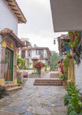 Pueblito Boyacense, Duitama, Boyac, Kolombiya 'da canlı çiçekler ve geleneksel mimari ile süslenmiş bir koloni caddesinin pitoresk bir görüntüsü..