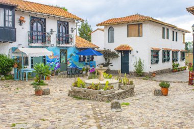 Pueblito Boyacense, Duitama, Boyac, Kolombiya 'da canlı çiçekler ve geleneksel mimari ile süslenmiş bir koloni caddesinin pitoresk bir görüntüsü..