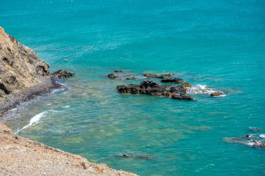 Cabo de la Vela, La Guajira, Kolombiya yakınlarında canlı turkuaz sularla çevrili bir kaya oluşumunun huzurlu bir görüntüsü..