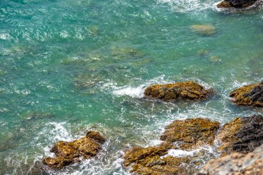 Cabo de la Vela, La Guajira, Kolombiya yakınlarında canlı turkuaz sularla çevrili bir kaya oluşumunun huzurlu bir görüntüsü..