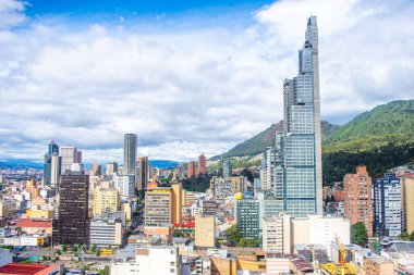 Bogot 'un bulutlu gökdelenlerin altında modern gökdelenleri sergilenen panoramik bir görüntüsü Kolombiya' nın canlı başkentinin özünü yakalıyor..