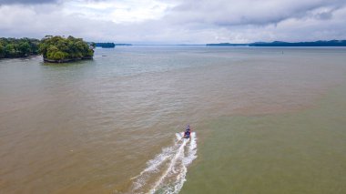 Bahia Malaga 'nın Valle del Cauca' daki hava manzarası yemyeşil ve tropikal ağaçlarla çevrili bir nehir boyunca tekneleri gösteriyor..