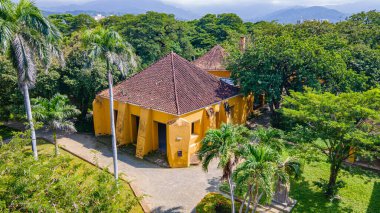 Tayrona Park, Santa Marta, Magdalena, Kolombiya 'daki yemyeşil çimlerle çevrili tarihi bir yapının havadan görünüşü.
