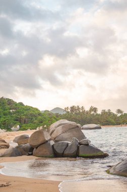 Tayrona Park, Santa Marta, Kolombiya 'da kayalar, kum ve yemyeşil deniz manzarası.