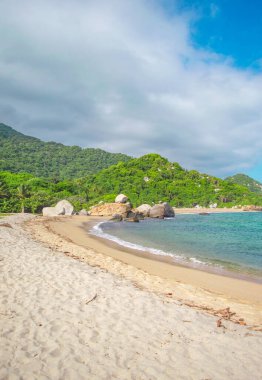 Tayrona Park, Santa Marta, Kolombiya 'da kayalar, kum ve yemyeşil deniz manzarası.