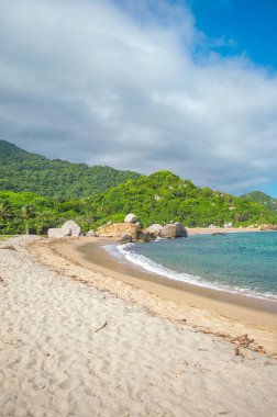 Tayrona Park, Santa Marta, Kolombiya 'da kayalar, kum ve yemyeşil deniz manzarası.