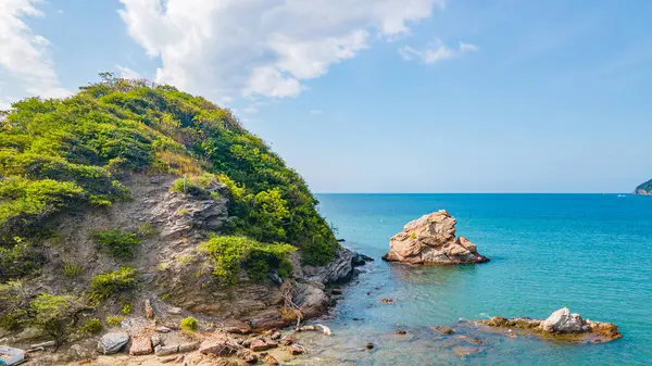 Bereketli yeşillik, kayalar ve Santa Marta, Magdalena 'da berrak mavi bir denizin yer aldığı güzel bir kıyı manzarası..