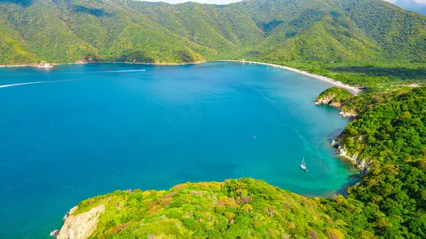 Kolombiya, Magdalena 'daki Santa Marta kıyı şeridinin çarpıcı hava manzarası, yemyeşil dağlar ve berrak mavi suların yer aldığı.