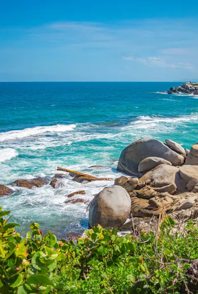 Tayrona Park, Santa Marta, Kolombiya 'da kayalar, kum ve yemyeşil deniz manzarası.