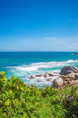 Tayrona Park, Santa Marta, Kolombiya 'da kayalar, kum ve yemyeşil deniz manzarası.