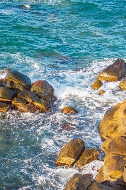 Tayrona Park, Santa Marta, Kolombiya 'da kayalar, kum ve yemyeşil deniz manzarası.