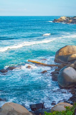 Tayrona Park, Santa Marta, Kolombiya 'da kayalar, kum ve yemyeşil deniz manzarası.