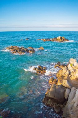 Tayrona Park, Santa Marta, Kolombiya 'da kayalar, kum ve yemyeşil deniz manzarası.