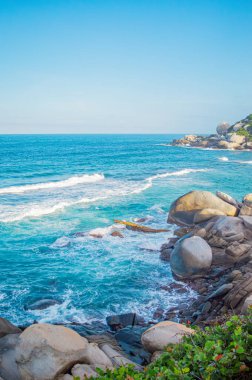 Tayrona Park, Santa Marta, Kolombiya 'da kayalar, kum ve yemyeşil deniz manzarası.