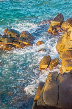 Tayrona Park, Santa Marta, Kolombiya 'da kayalar, kum ve yemyeşil deniz manzarası.