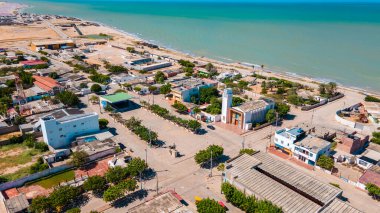La Guajira, Kolombiya 'da muhteşem bir kıyı kasabası, canlı evler, palmiye ağaçları ve güzel okyanus manzarası..