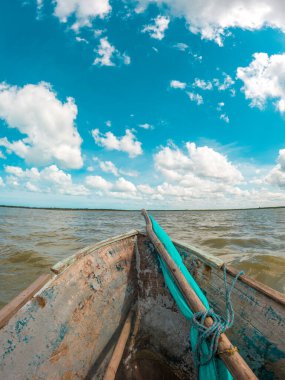 La Guajira, Kolombiya 'nın sularındaki kırsal bir tekneden sakin bir manzara, tüylü bulutlarla dolu güzel mavi bir gökyüzünü gösteriyor..