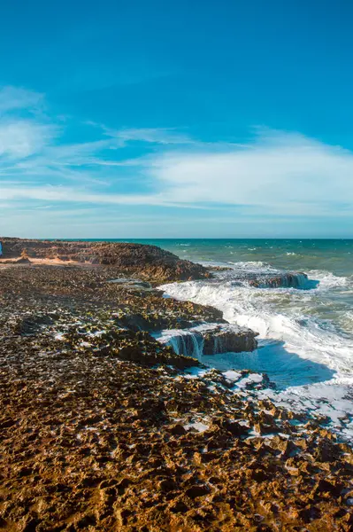 Güzel kayalık kıyı şeridi La Guajira, Kolombiya 'da açık mavi gökyüzünün altında dalgalar çarpışıyor..