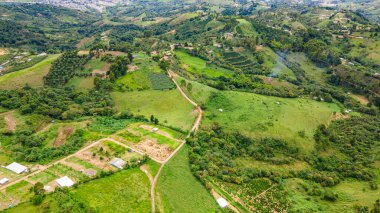 Popayn, Cauca, Kolombiya 'nın canlı yeşil tepelerini ve tarlalarını gösteren çarpıcı hava manzarası, bölgenin doğal güzelliğini vurguluyor..