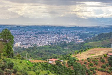 Popayn, Cauca 'nın çarpıcı panoramik manzarası, yeşil tepeler ve bulutlu gökyüzüne karşı şehir manzarasını gözler önüne seriyor..
