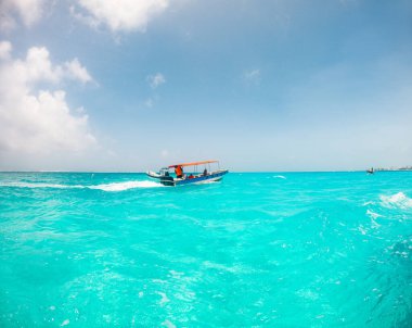Kolombiya 'nın San Andres Adası açıklarında berrak mavi gökyüzünün altında turkuaz sularda yüzen bir teknenin manzarası..
