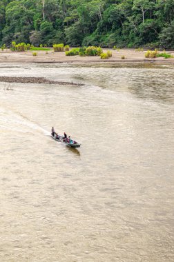 İnsanları taşıyan bir tekne Kolombiya 'daki Putumayo Nehri' nin sakin sularında dolanıyor..