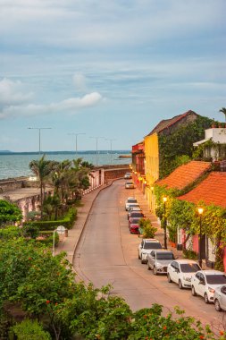Kartagena, Kolombiya 'nın tarihi merkezinde büyüleyici bir cadde. Renkli binalar, palmiye ağaçları ve manzaralı okyanus manzaralı..