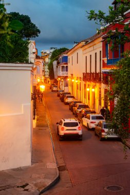 Kolombiya, Cartagena 'da büyüleyici tarihi bir cadde, sıcak sokak lambalarıyla aydınlatılmış, canlı bir mimari ve huzurlu bir ortam sergileniyor..