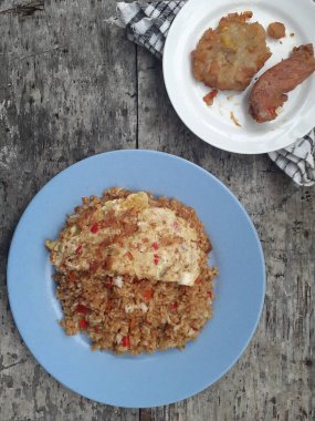 Özel kızartılmış pilav ve bir tabakta çırpılmış yumurta. Tadı çok güzel. Endonezya halkı için popüler bir yemek. Üst görünüm.