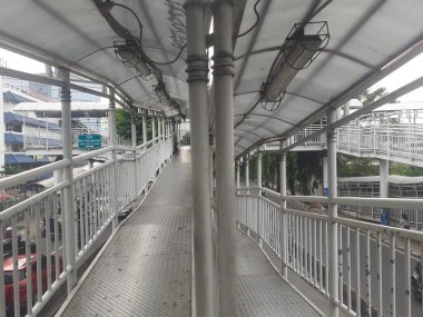 Jakarta, Endonezya, Kasım 28, 2022: Yaya geçidi köprüsü tasarımı ve sabah saatlerinde görülen Transjakarta otobüs yolcuları için otobüs durağı tasarımı.