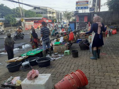 Jakarta, Endonezya, 13 Aralık 2022: Geleneksel bir yol kenarı pazarının atmosferi terk edilmiş görünüyor, bazı satıcılar kapalı, bazıları hala alıcılarına hizmet veriyor.