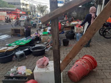 Jakarta, Endonezya, 13 Aralık 2022: Geleneksel bir yol kenarı pazarının atmosferi terk edilmiş görünüyor, bazı satıcılar kapalı, bazıları hala alıcılarına hizmet veriyor.