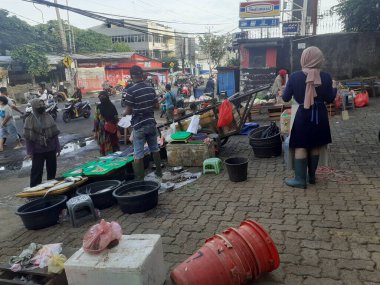 Jakarta, Endonezya, 13 Aralık 2022: Geleneksel bir yol kenarı pazarının atmosferi terk edilmiş görünüyor, bazı satıcılar kapalı, bazıları hala alıcılarına hizmet veriyor.
