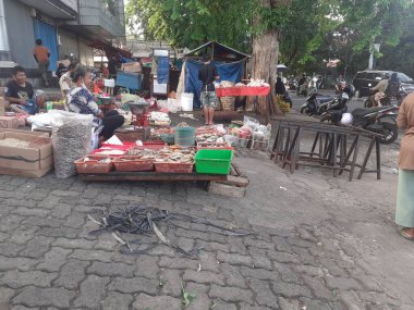 Jakarta, Endonezya, 13 Aralık 2022: Geleneksel bir yol kenarı pazarının atmosferi terk edilmiş görünüyor, bazı satıcılar kapalı, bazıları hala alıcılarına hizmet veriyor.