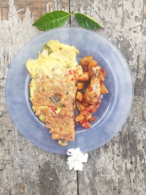 Kahvaltı spesiyali, doldurulmuş omlet menüsü, patates ve kızarmış tavuk tabakta. Ev yapımı. Ahşap arka plan..