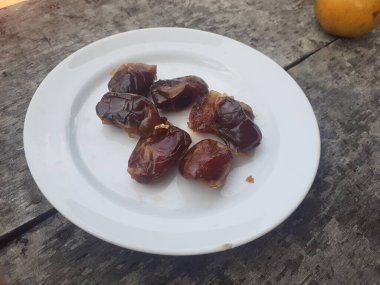 Phoenix Dactylifera bilimsel tarihler. Tabakta tarihler. Ahşap zemin. Tarihler, her an büyüyebilen bir meyve türü..