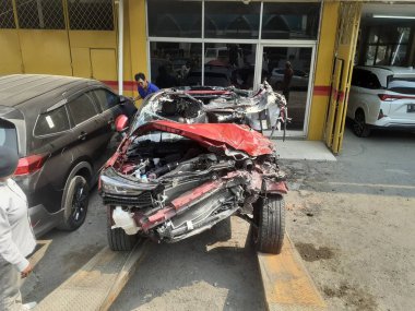 Cakarta, Endonezya, 11 Ekim 2023: Bir araba bir kaza sonucu çok kötü hasar gördü, çekiciden araba servisi atölyesine indirildiğinde görüldü.