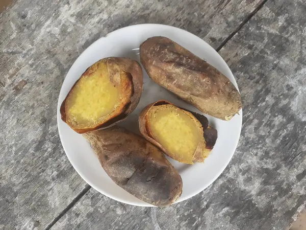 Cilembu sweet potato roasted with honey on a small plate. Wooden table background. Cilembu sweet potato is a local breed of sweet potato cultivar from Cilembu village.