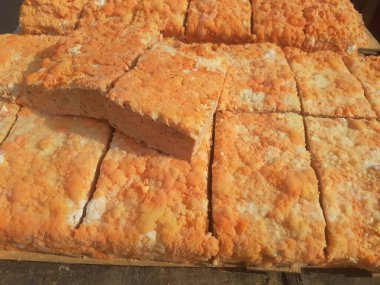 Geleneksel bir yol kenarı pazarında ahşap bir rafta çiğ oncom. Oncom, yer fıstığı keki ve tofu dreglerinden yapılan mantar ezmeli bir tempeh. Oncom, çeşitli küf türleri olan mayalanmış bir yemektir..