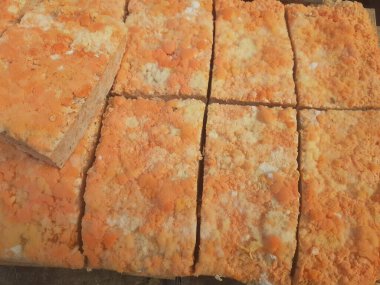 Geleneksel bir yol kenarı pazarında ahşap bir rafta çiğ oncom. Oncom, yer fıstığı keki ve tofu dreglerinden yapılan mantar ezmeli bir tempeh. Oncom, çeşitli küf türleri olan mayalanmış bir yemektir..