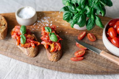 Tahta kesme tahtasının üzerinde domatesli klasik bruschetta..