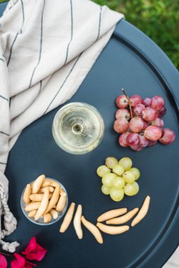 Masada aperatiflerle birlikte bir bardak beyaz şarap..